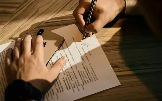 Mano revisando un documento con bolígrafo